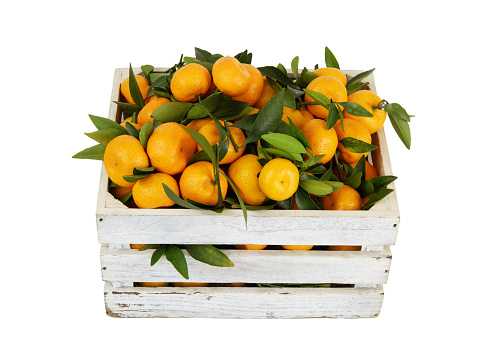Many mandarins in white wooden crate isolated on white background.