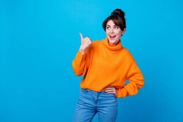 istock Photo of funky impressed lady wear knitted pullover pointing thumb looking empty space isolated blue color background 1846755392