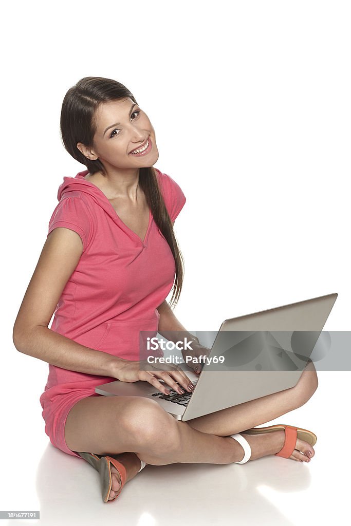 casual mujer sonriente sentado en el suelo con el ordenador portátil - Foto de stock de Adolescente libre de derechos