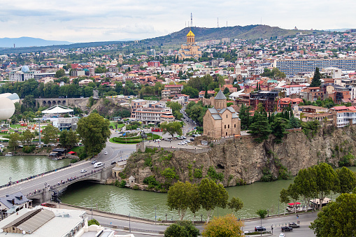 Tbilisi, Georgia - September 23, 2023: above view of Tbilisi city with Metekhi from Narikala fortress on cloudy autumn day