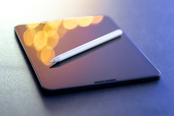 Designer workspace with digital tablet and stylus pen on the table close-up.
