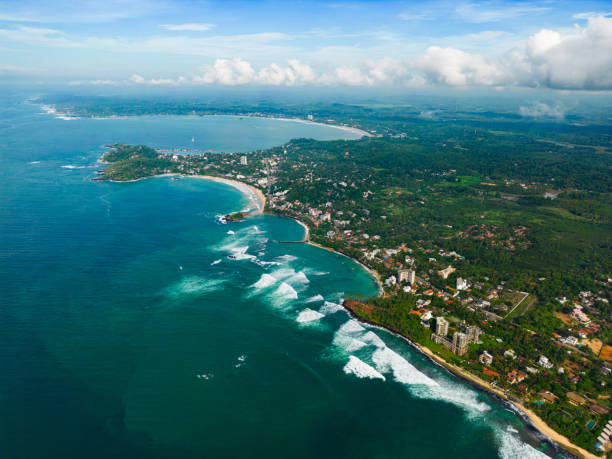 istock Aerial view with panoramic coastline with sparkling turquoise waters against a lush green landscape, showcasing scenic coastal living and the junction between land and sea from birds-eye perspective. 1846775604
