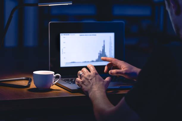 istock Man trading, browsing online stock investments at night. 1846778295