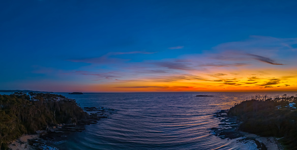 Early morning aerial views over the sea and lagoon at Lilli Pilli Beach in the Eurobadalla Shire on the South Coast, NSW, Australia.