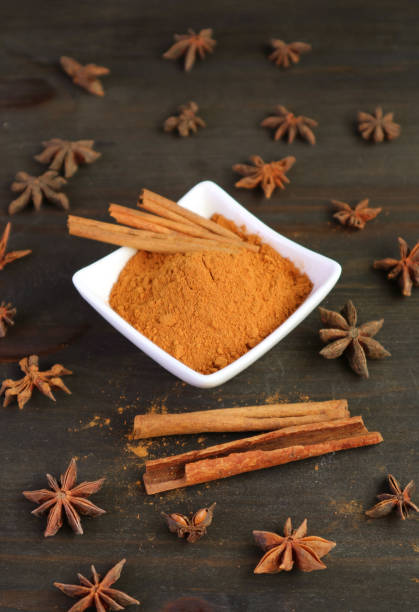 istock Ground cinnamon powder and sticks with star anise scattered around 1846810912