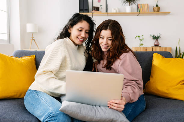 istock Happy latin american student woman using laptop computer sitting on sofa at home 1846814086