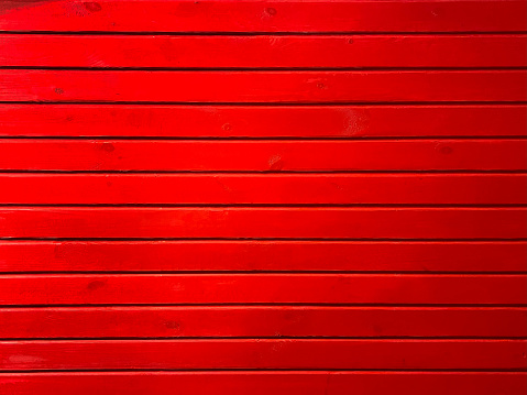 Red painted panoramic wooden wall made of vertical boards in close-up