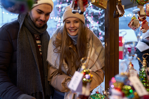Caucasian couple having fun on Christmas market at night