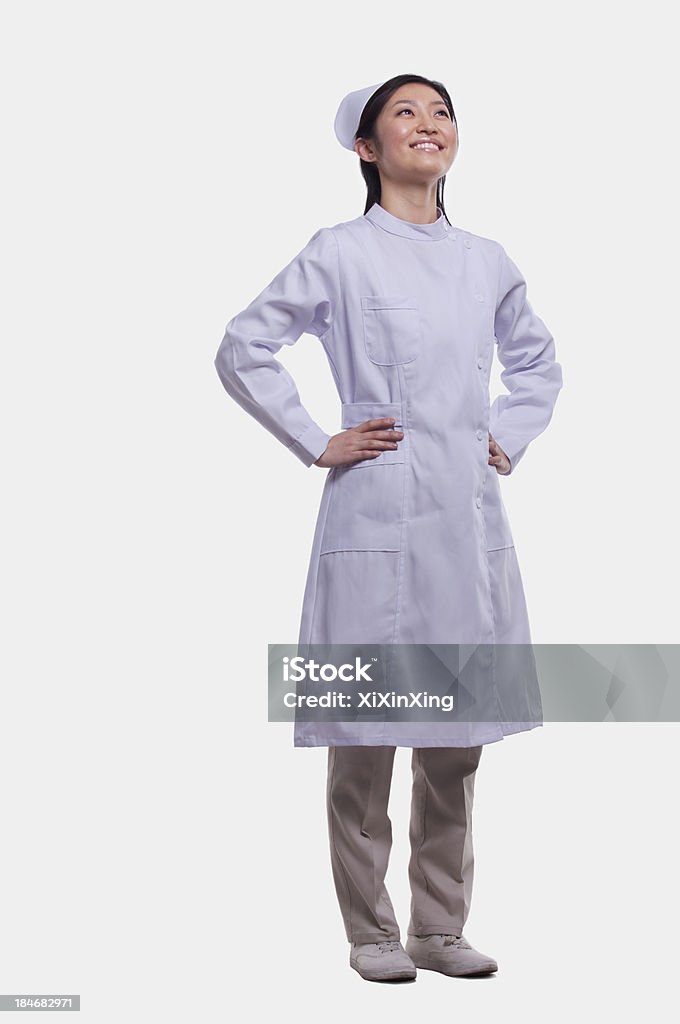 Retrato de enfermera con las manos sobre la cadera; Foto de estudio - Foto de stock de 20-24 años libre de derechos