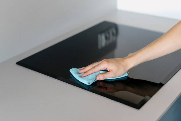 istock Selective focus on woman hand holding blue rug and cleaning black empty ceramic stove 1846838732