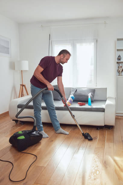 istock Man cleaning apartment with vacuum cleaner. 1846842002