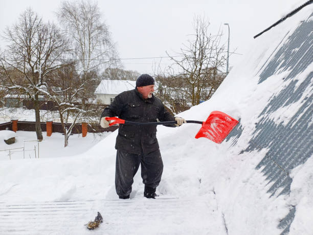 istock An elderly man clears snow from a roof with a red shovel 1846842026