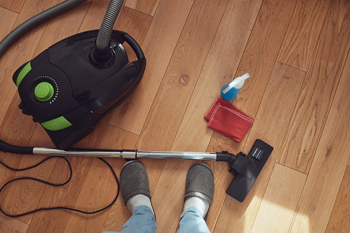 Man cleaning apartment with vacuum cleaner.