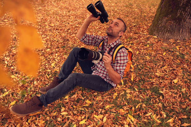 istock Man using binoculars and camera for bird and animal watching in nature. 1846847006