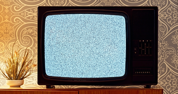 Close-up of snow on old television screen in living room.