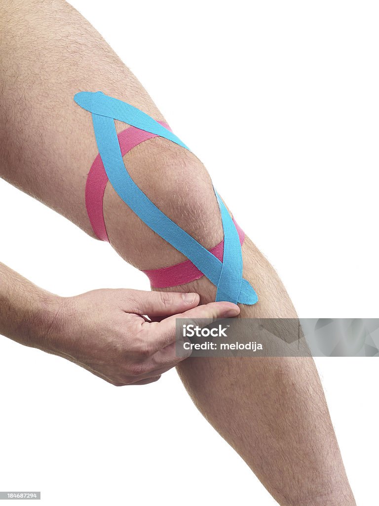 Therapeutic treatment of knee with kinesio tex tape. Therapeutic treatment of knee with kinesio tex tape. Kinesiotape is used for prevention and treatment in competitive sports. Physiotherapy. Rehabilitation. Adhesive Bandage Stock Photo