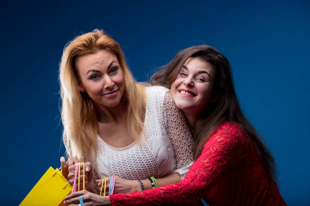 Humorously, a young woman pretends to swipe all shopping, friend reacts in mock surprise