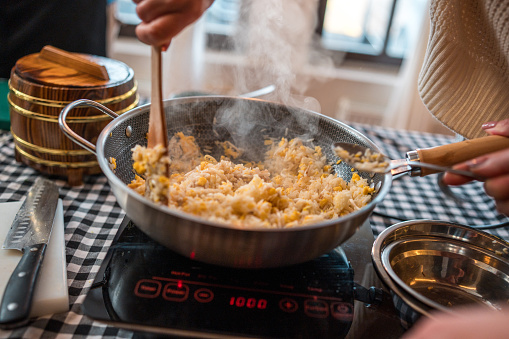 Close-up of people experiencing Chinese culinary cooking skills by making egg stir-fry rice With Chinese cooking tutors on a cooking class.