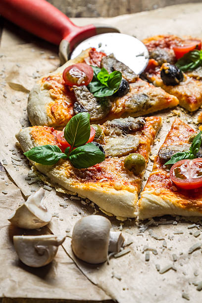 istock Cutting homemade pizza on old table 184690011