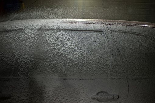 Washing car. Car in car wash. Foam on transport. Soapy solution.