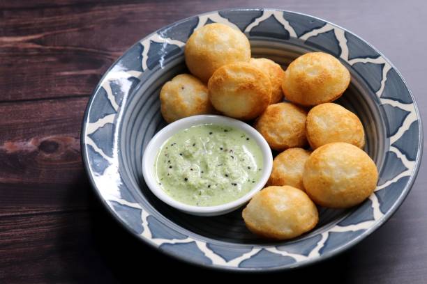 istock Paniyaram are savory balls made using fermented rice and urad dal batter along with tempered onion and spices. Also known as Paddu, Ponganalu, Kuli, bugga, and appe. served with coconut chutney 1846909135