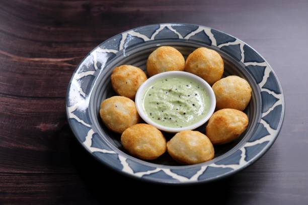 istock Paniyaram are savory balls made using fermented rice and urad dal batter along with tempered onion and spices. Also known as Paddu, Ponganalu, Kuli, bugga, and appe. served with coconut chutney 1846909140