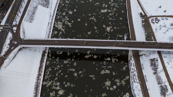 Drone photography of footbridge over a river in a city during winter day