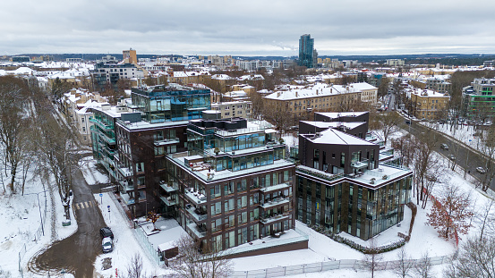 Drone photography of city street and surrounding buildings in snow during winter day
