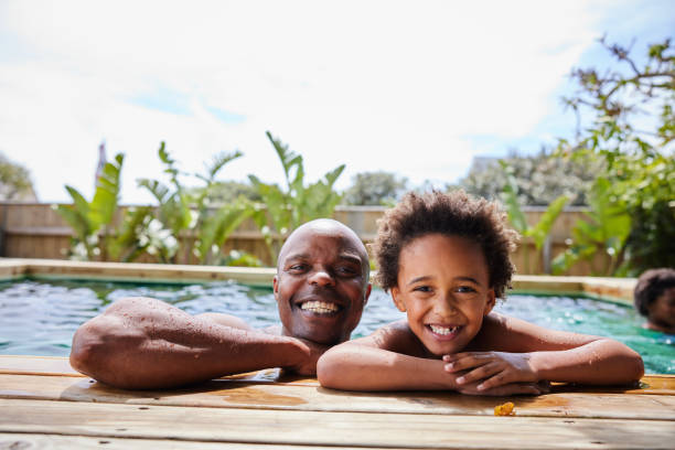 istock Smiling dad and his son swimming in a pool in summer 1846941618