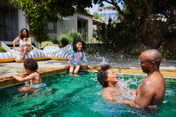 istock Dad playing with his children in a pool with their mom watching in summer 1846947115