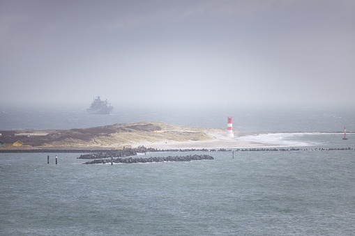 A scenic view of a lighthouse on Fork Island in Nebel, Helgoland, Germany on a foggy day