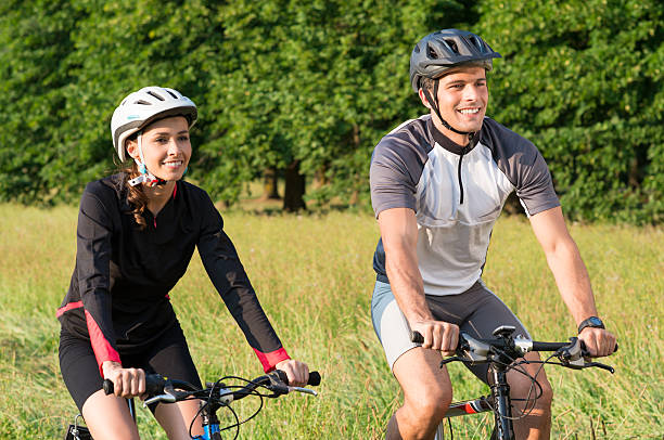istock Young Couple Riding Bicycle In Meadow 184695576
