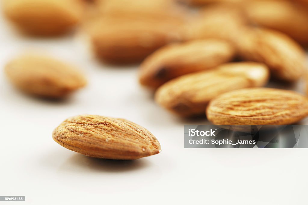Handful of almonds on a white background A handful of almonds shot against a white background. "Almond" is also the name of the edible and widely cultivated seed of this tree Almond Stock Photo