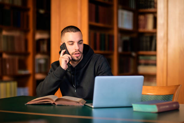 istock Handsome young man sitting in the university library and learning 1847006169
