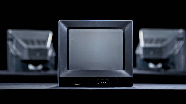 Close-up of old television set against black background.