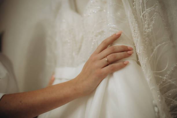 istock Bride.Preparations.Wedding.Manicure. Bride touch beads on your white wedding dress by hand with pearl nails. 1847014022