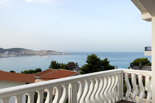Woman tourist enjoying a view of the blue mediterranean sea and coastline through white arches of the Balcon de Europa