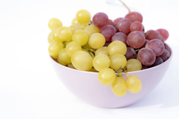 istock White and red grapes in pink plastic bowl. 1847026591
