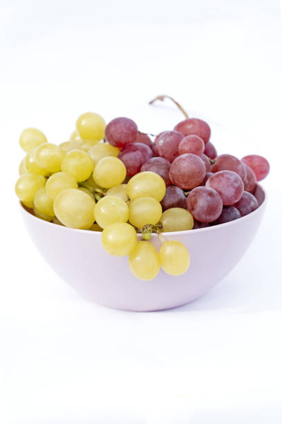 istock White and red grapes in pink plastic bowl. 1847026598