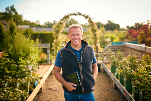 istock Portrait Of Mature Man Working Outdoors In Garden Centre Using Digital Tablet 1847031395
