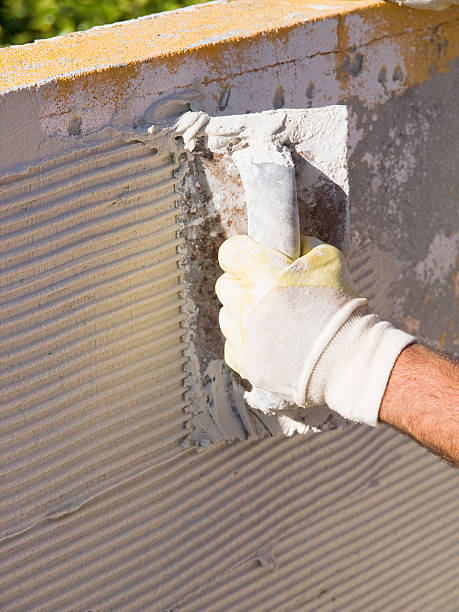 istock Man spreading tile adhesive with a trowel 184703628