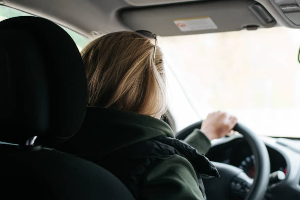 istock Back view of a young woman driver driving a car, selective focus 1847044581