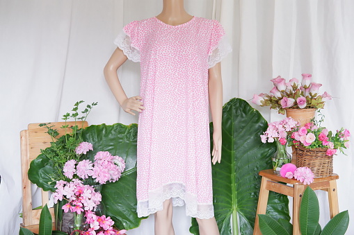 Tailor mannequin with pink dress on white background.