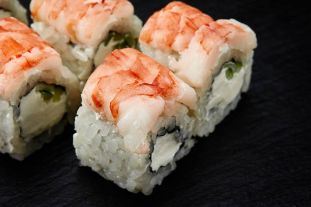 istock Sushi rolls Philadelphia with snow crab, cream cheese, cucumber, sesame seeds isolateed on black background. Japanese oriental cuisine 1847072105
