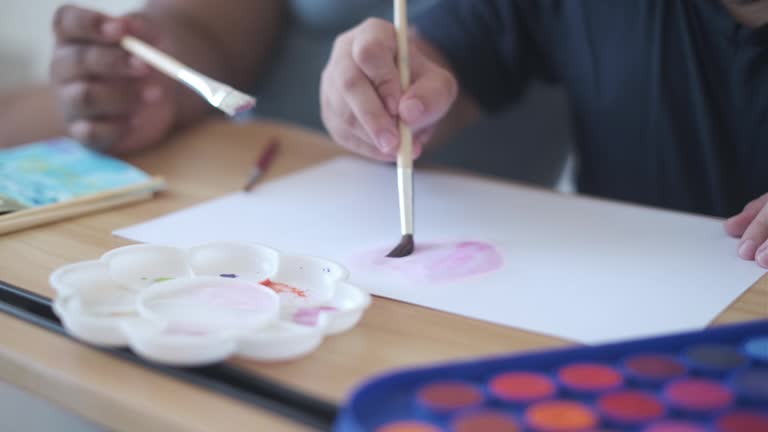 Unrecognizable Little Girl Hand Painting With Watercolor on Paper