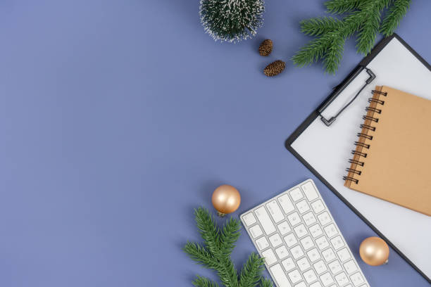 istock Office desk table with computer keyboard, paper clipboard, notepad and Christmas decorations on pastel blue background. 1847079176