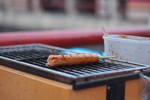 Indonesian street vendors prepare sausages outdoors