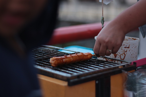 Indonesian street vendors prepare sausages outdoors