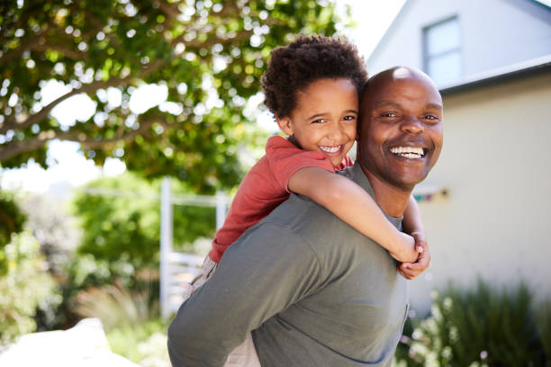 istock Dad carrying his cute little son on his back outside in summer 1847084787