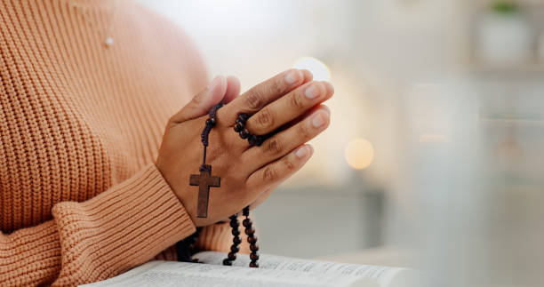 closeup hands, rosary and a bible for prayer, spiritual support and hope from jesus. house, god and a person with a cross and book for help, trust and gratitude as a christian for the gospel - jesus christ human hand god consoling imagens e fotografias de stock